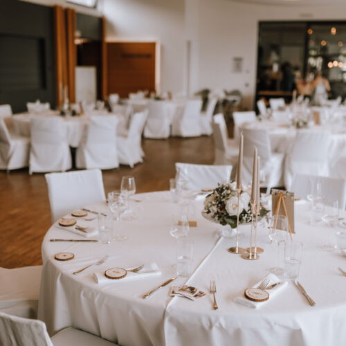 Mehrere Tische sind eingedeckt für eine Hochzeit